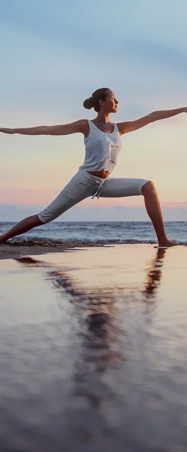 A woman doing a yoga pose on the beach, a stock photo by Wu Wei, shutterstock contest winner, arabesque, dynamic pose, stock photo, dynamic composition